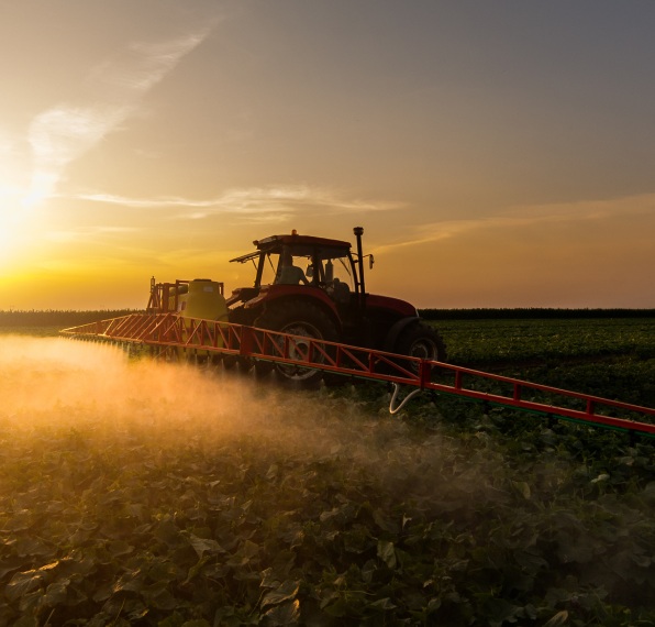 Trator aplicando herbicida na plantação.
