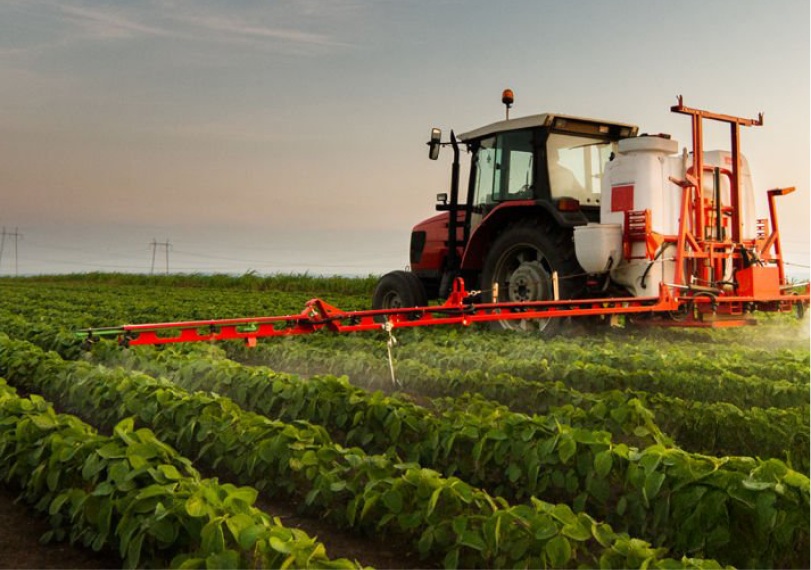 Trator aplicando herbicida na plantação.