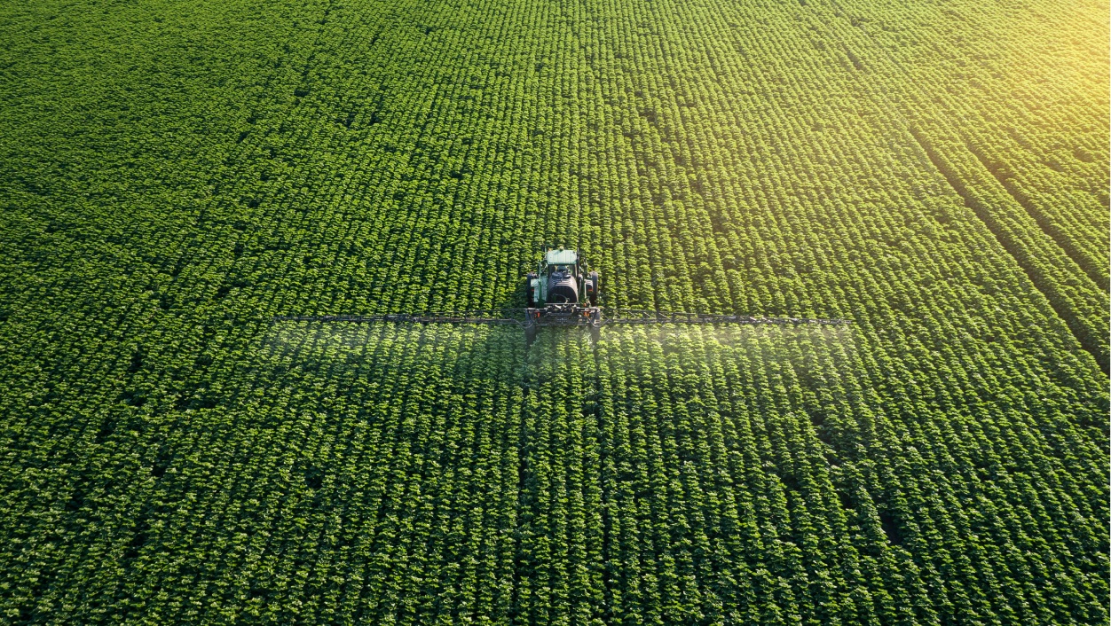 Trator aplicando herbicida na plantação.